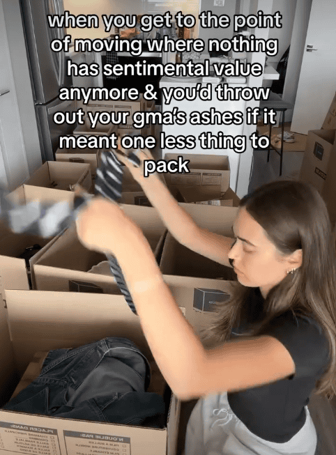 Moving boxes and packing scene at Pleated Jeans office with a woman packing items into boxes.