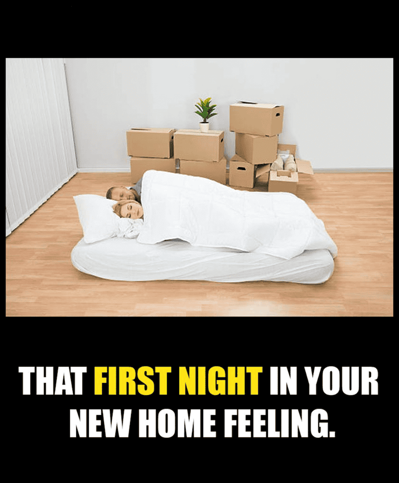 Couple sleeping on mattress with moving boxes in new home.