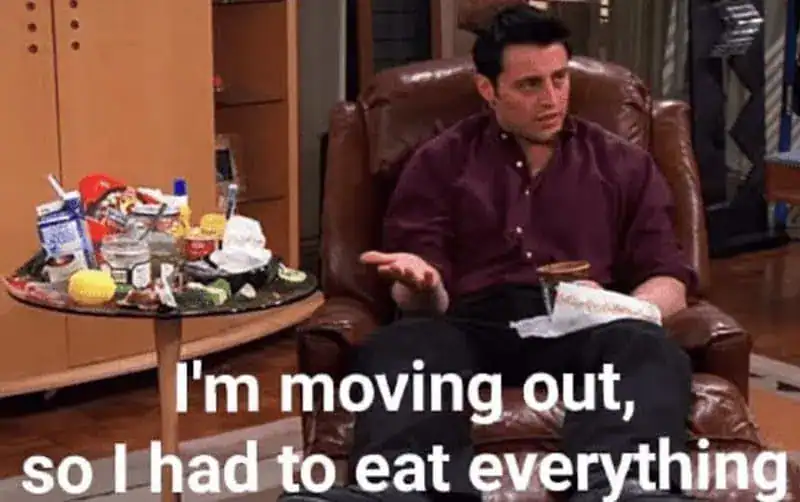 Man sitting on a chair with messy food and trash around him, expressing frustration.