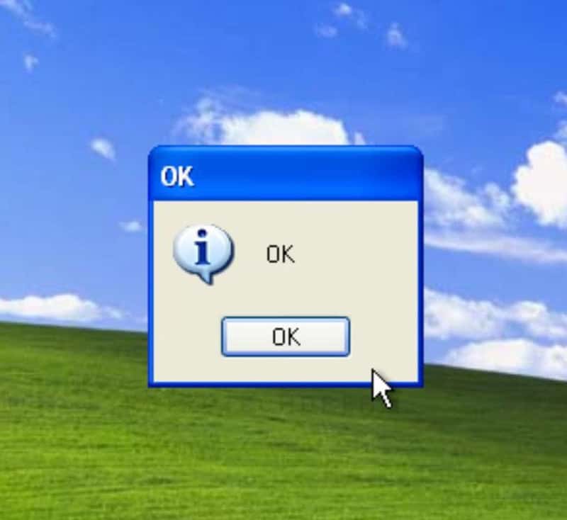 Windows OK dialog box on a grassy desktop background with blue sky and clouds.