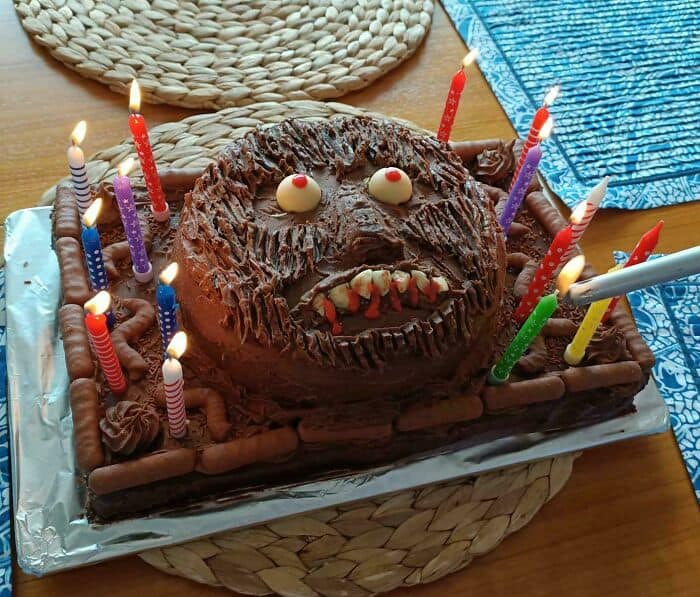 Unusual cake featuring a face with candles, resembling a creepy or cursed food theme. Perfect for a.