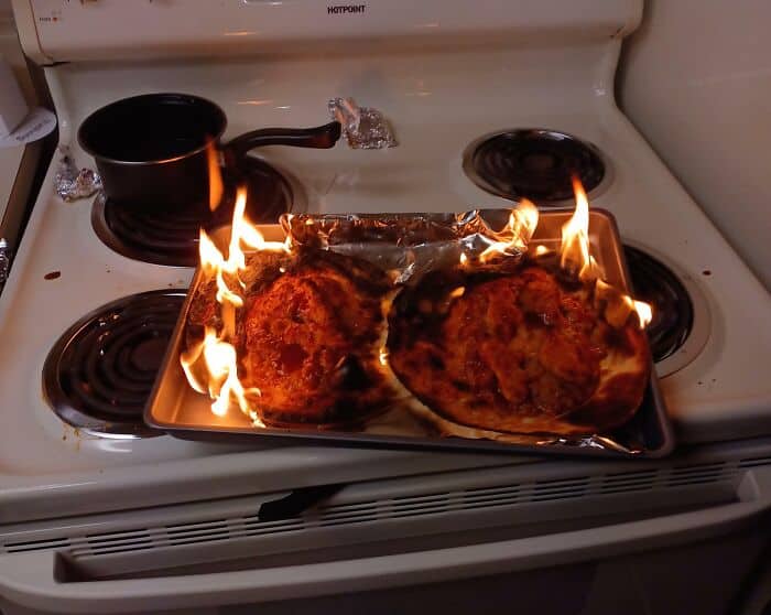 Cursed food on stove with flames and foil-wrapped items.