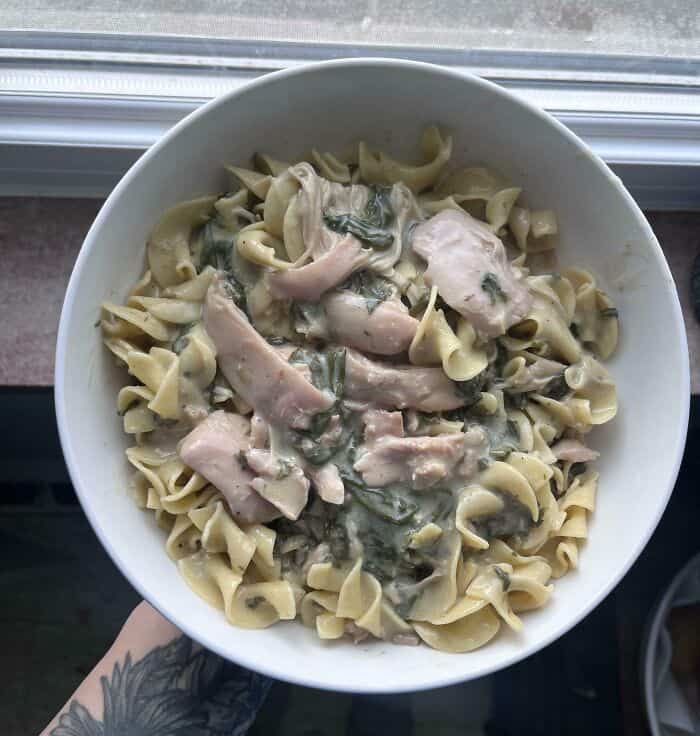 Creamy chicken and spinach pasta dish with tender chicken pieces and fresh spinach in a rich sauce.
