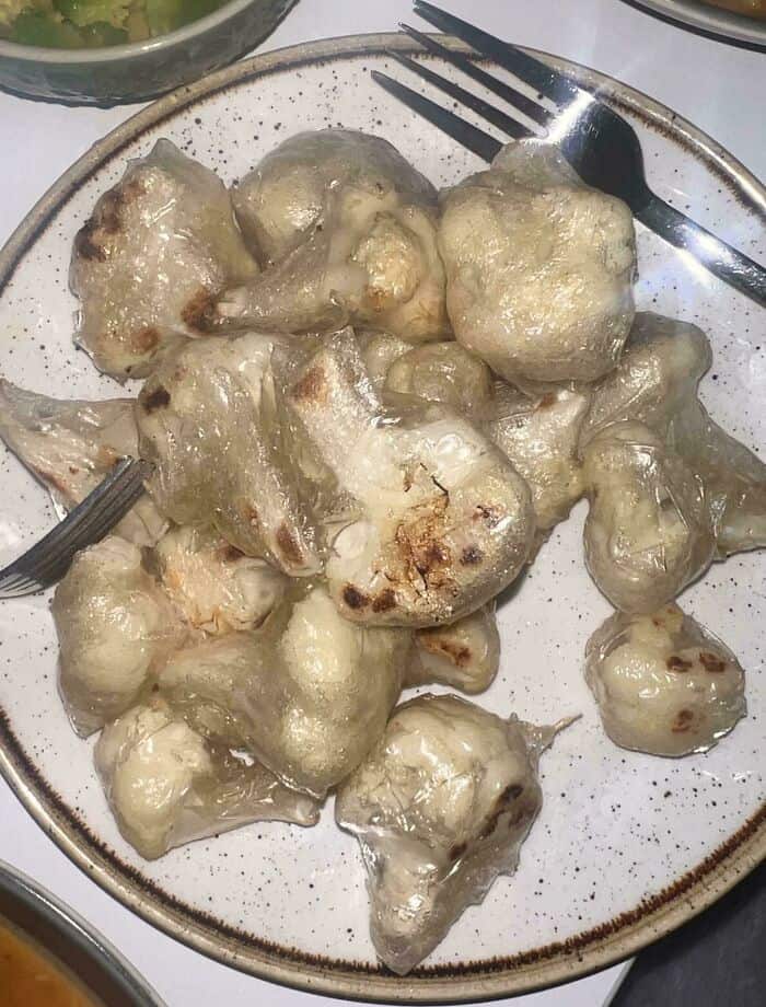 Moldy, spoiled food with white and green patches on a plate.