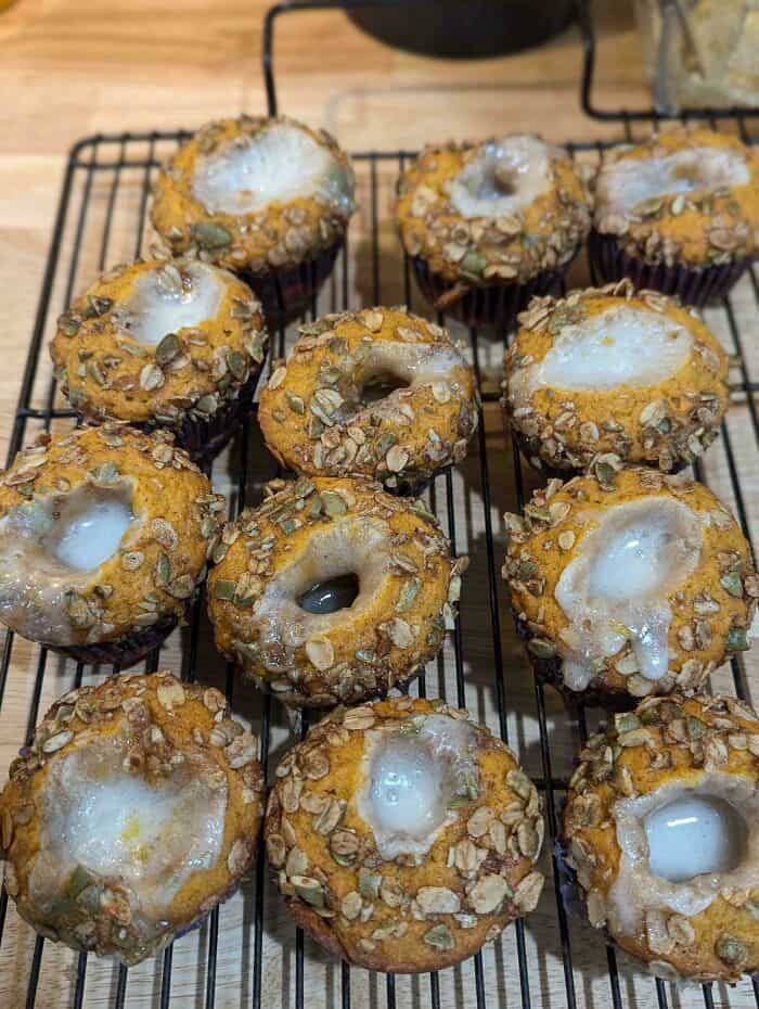 Delicious baked muffins with oat topping and white icing, perfect for a sweet treat.