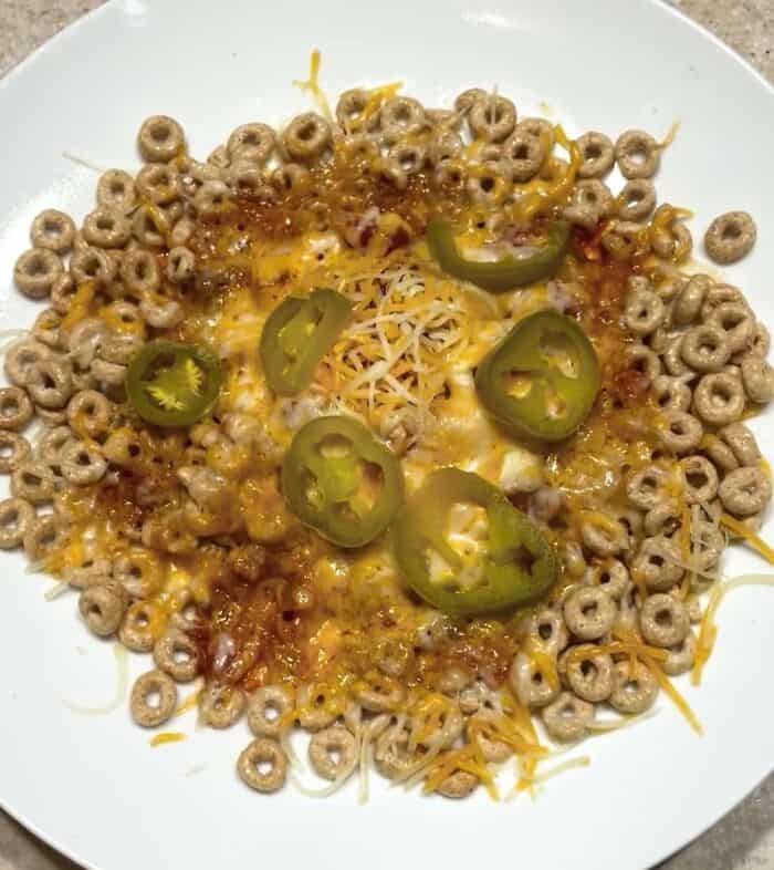 Unusual cheesy cereal dish topped with jalapeños and shredded cheese.