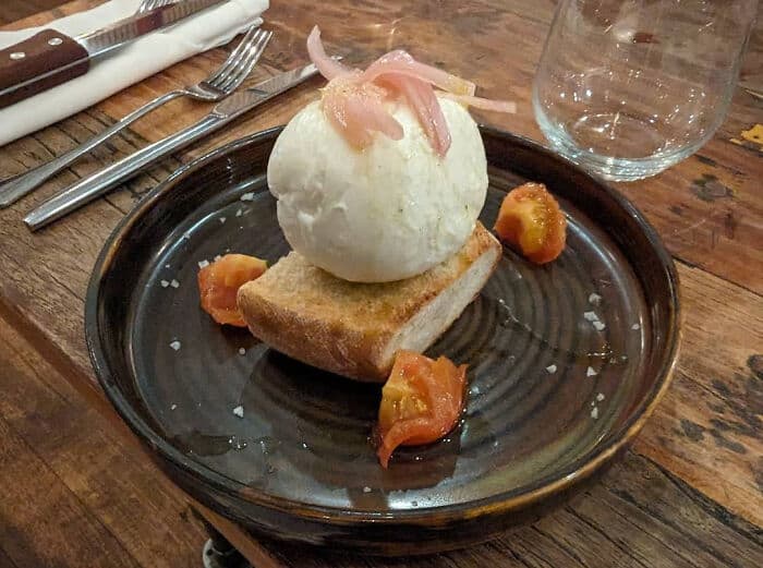Cursed food dish featuring a scoop of ice cream on a piece of toast with fruit garnish, presented on.