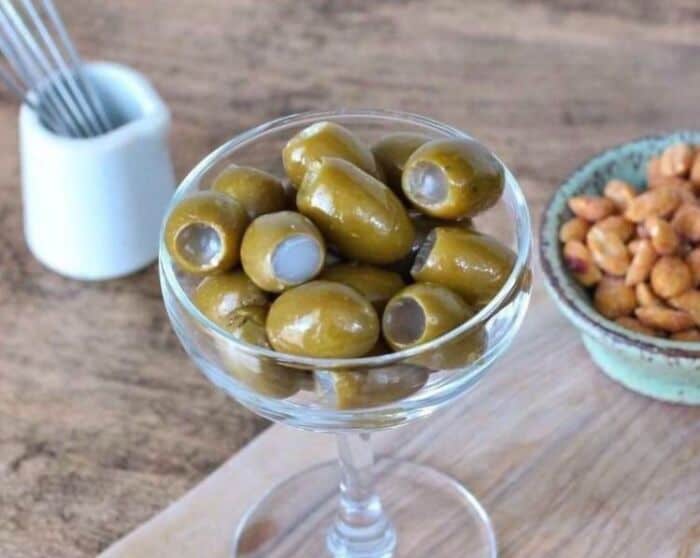 Green olives in a glass bowl, part of cursed food collection.
