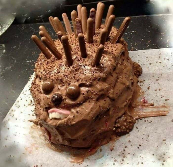 Cursed food cake resembling a face with chocolate sticks and candies, perfect for bizarre dessert th.