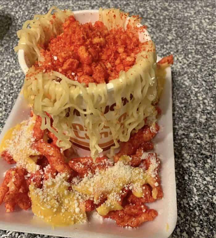 Spaghetti cup filled with tomato sauce, topped with cheese and crumbs, served with extra sauce and g.