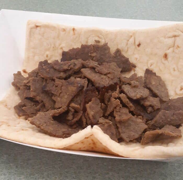 Close-up of beef fajita filling in a soft taco shell.