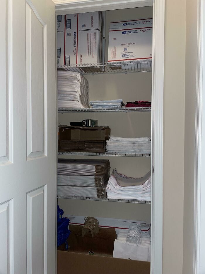 Organized closet with neatly stacked papers, boxes, and supplies on wire shelves.