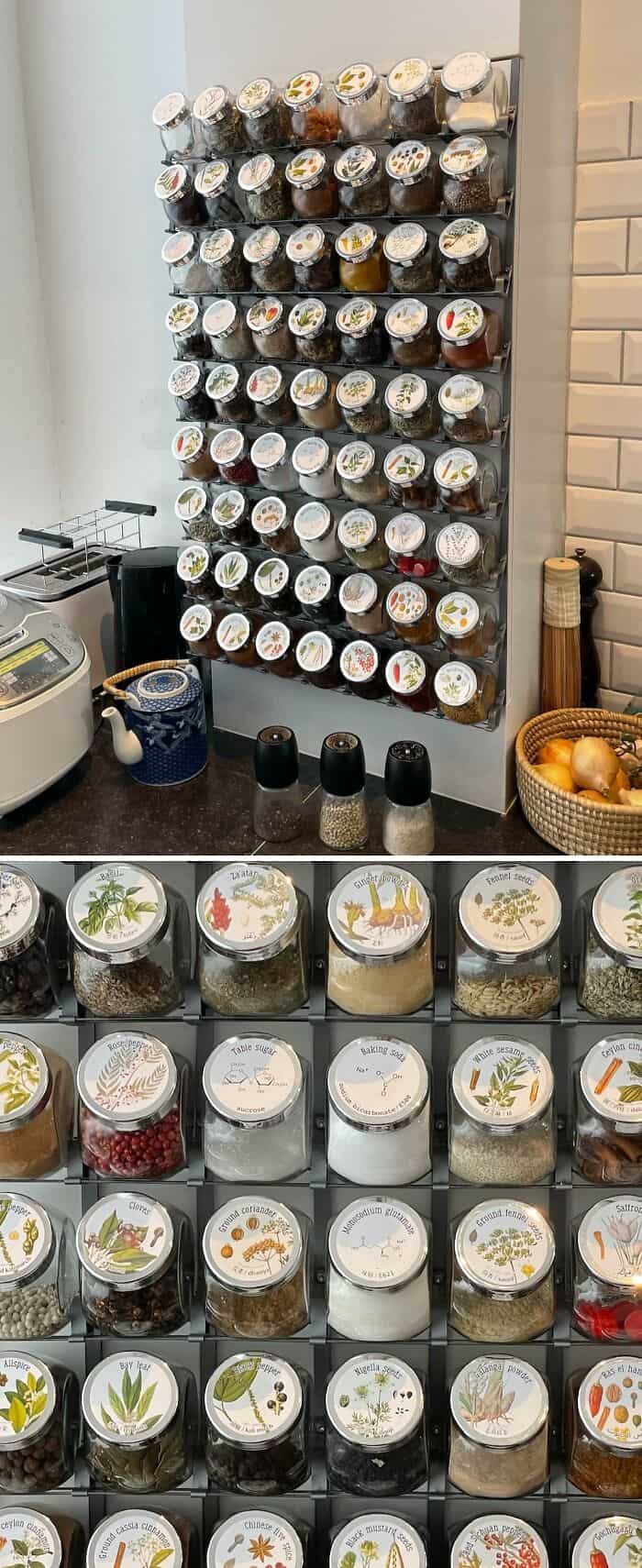 Spice jars neatly arranged on a wall-mounted rack for easy access and storage. Perfect for a tidy, o.
