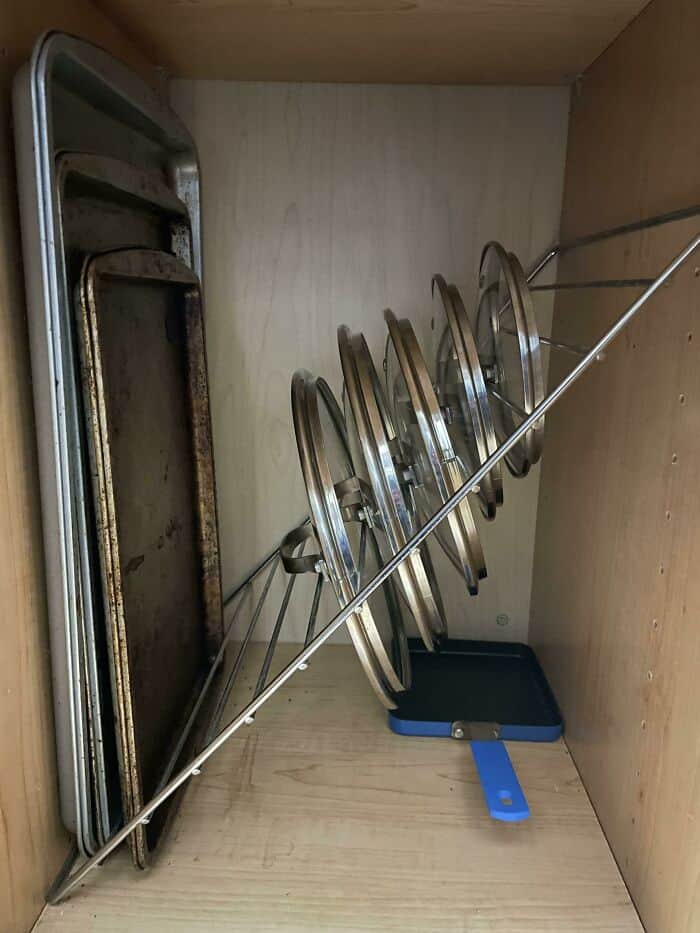 Efficiently arranged cooling racks and baking sheets in a cabinet for easy access and space optimiza.