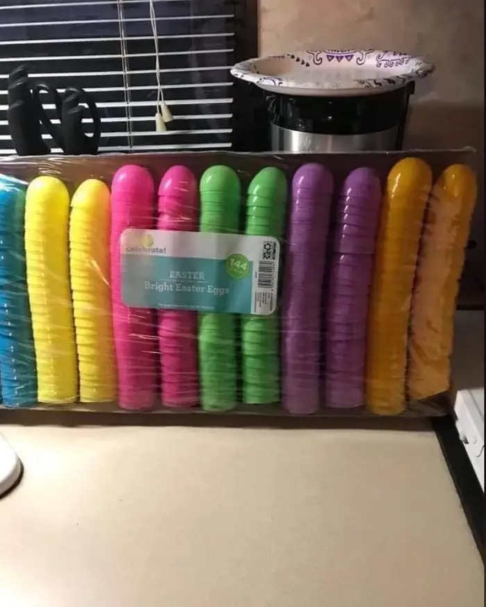 Brightly colored plastic Easter eggs in yellow, pink, green, purple, and orange, arranged in a row o.