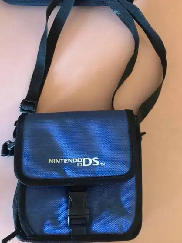 Durable blue Nintendo DS carrying bag with adjustable strap and secure buckle closure.