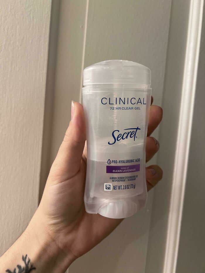 CLINICAL Secret 72 HR Clear Gel deodorant in hand against a door frame.