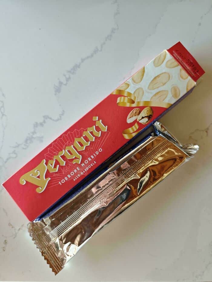 Vegan Toroneggio almond chocolate bar in silver foil wrapper on marble surface.
