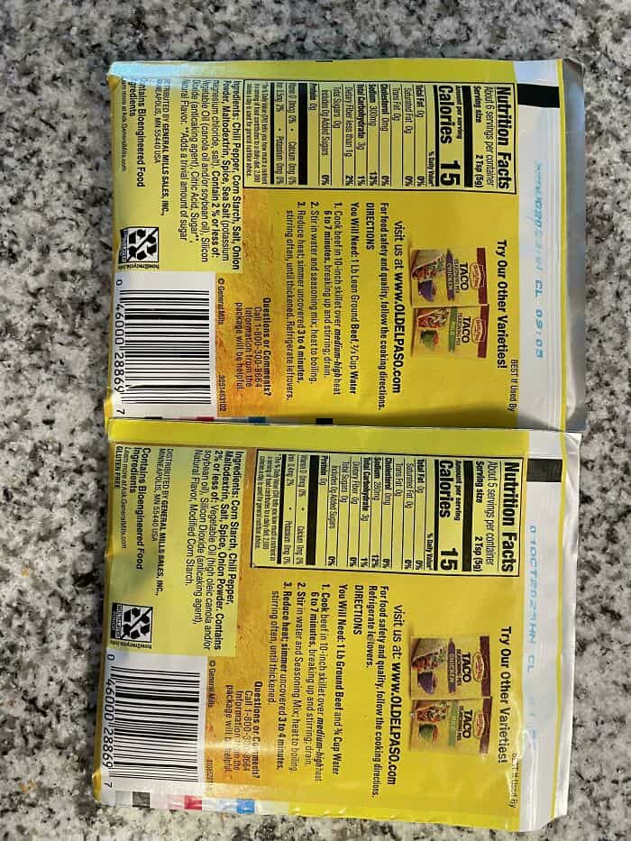 "Back of two snack packages showing nutrition facts and ingredients in yellow packaging".
