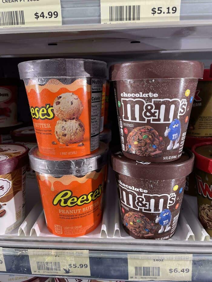 Reese's and M&M's ice cream pints on store shelf.