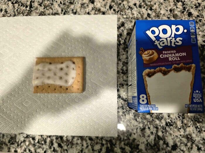 Miniature cookie with white icing and chocolate chips next to a box of Frosted Cinnamon Roll Pop-Tar.