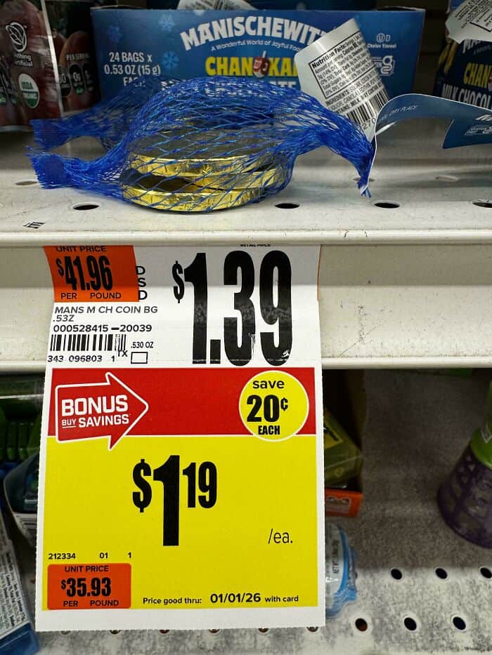 Mini Manischewitz Chanukah chocolate coin in blue mesh bag, on store shelf.
