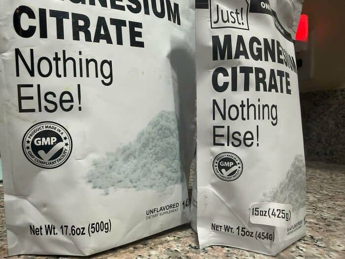 Epsom salt bags with "Nothing Else!" and "GMP" certification logos on a countertop.