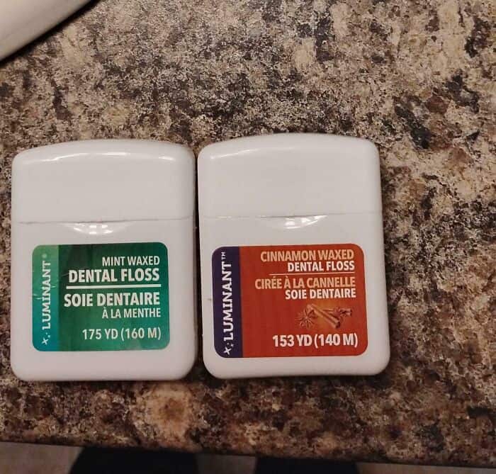 Mint Waxed Dental Floss and Cinnamon Waxed Dental Floss containers on a granite surface.