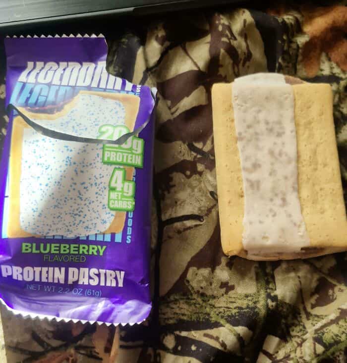 Blueberry flavored protein pastry with packaging and pastry on camouflage fabric.