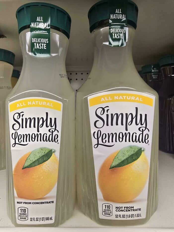 All natural Simply Lemonade bottle with lemon and leaf illustration, on store shelf.