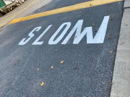 Stop sign painted upside down on asphalt road.