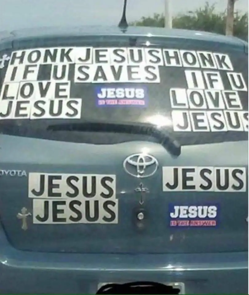 Car trunk decorated with humorous Jesus-themed stickers and messages.