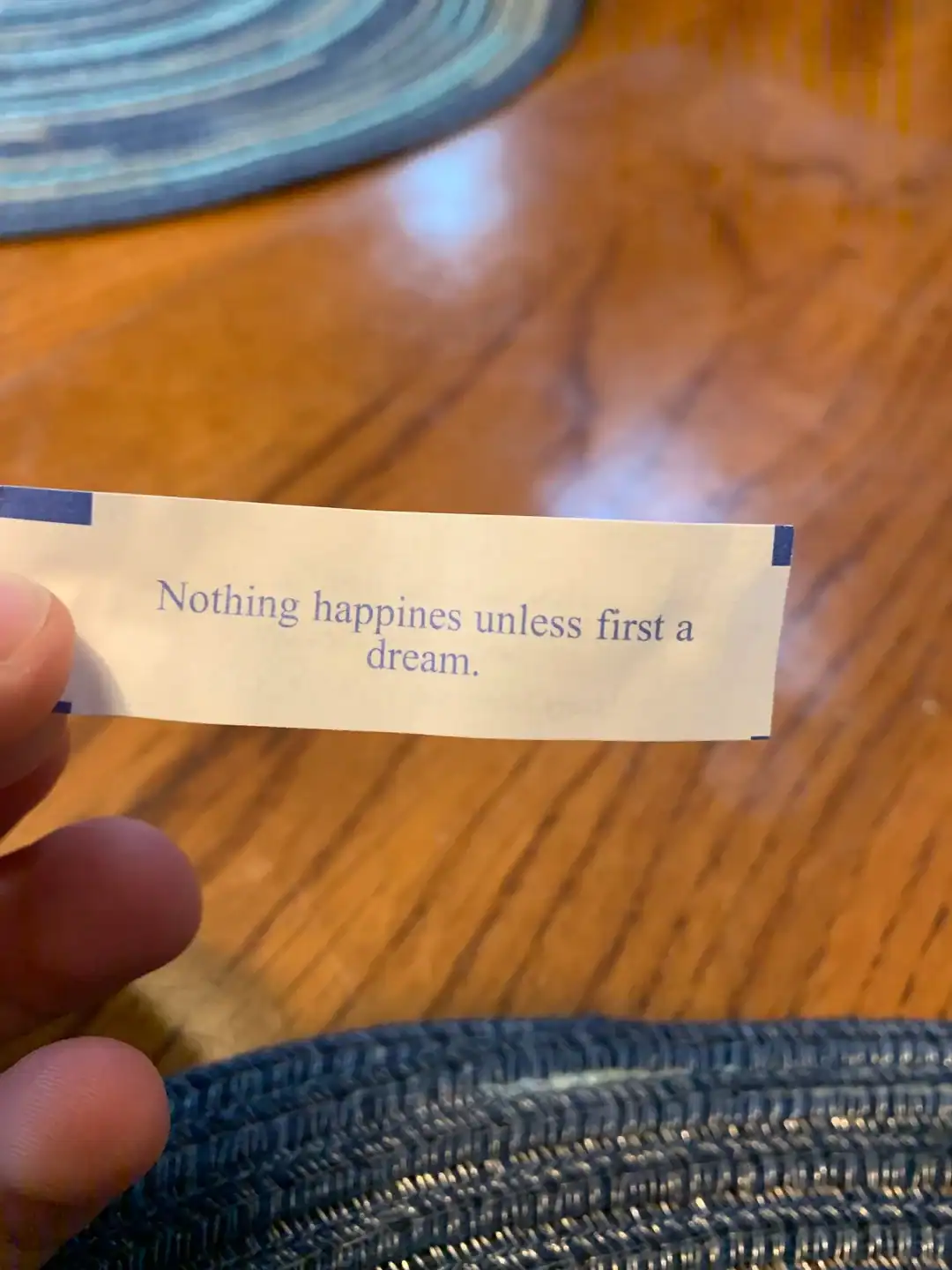 Inspirational quote on paper reading "Nothing happiness unless first a dream".