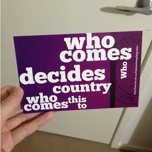 Hand holding a card with misspelled "who comes" and "this to" text.