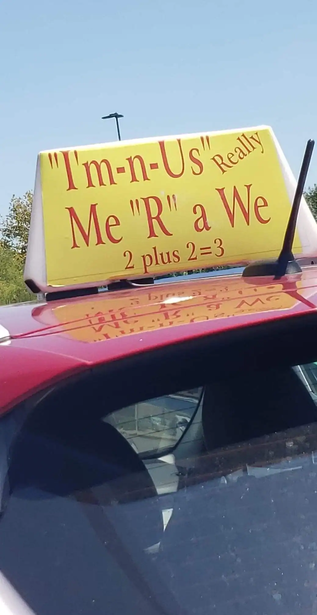 Humorous taxi sign with playful spelling errors and math joke about "I'm-n-U's" and "R" a We".