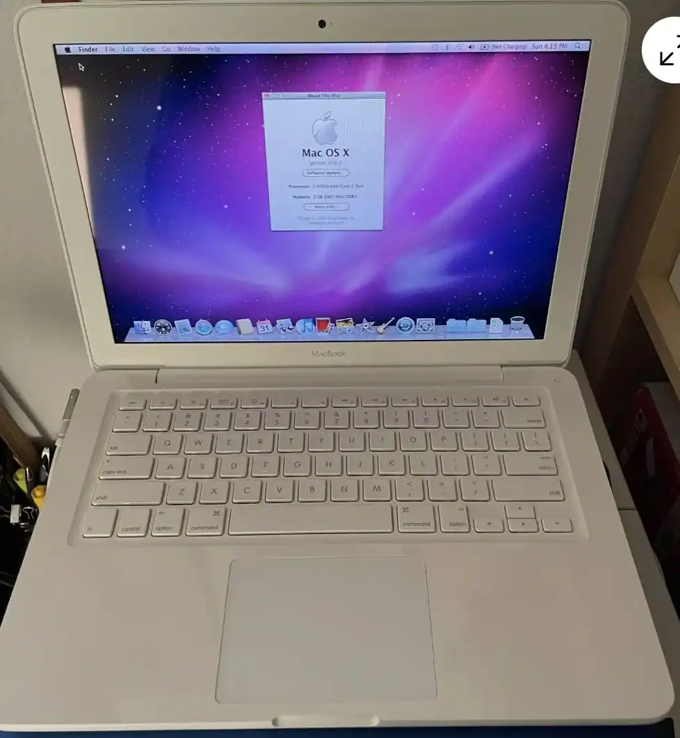 White MacBook Air displaying Mac OS X desktop with galaxy-themed background.