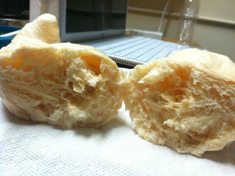 Freshly baked bread torn apart, soft and airy interior.