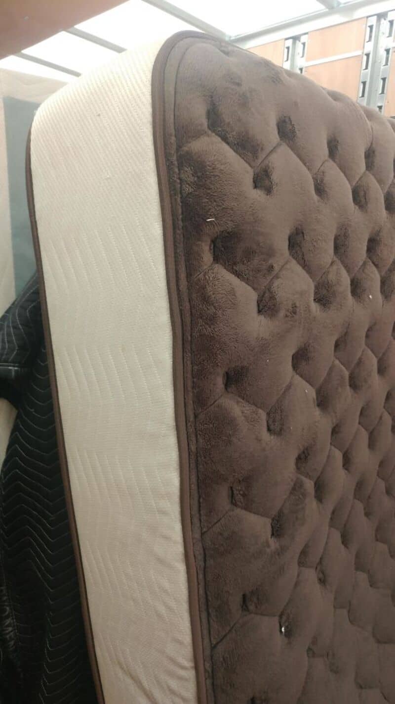 Tufted brown mattress with beige side panel, showcasing plush fabric and quilted design.