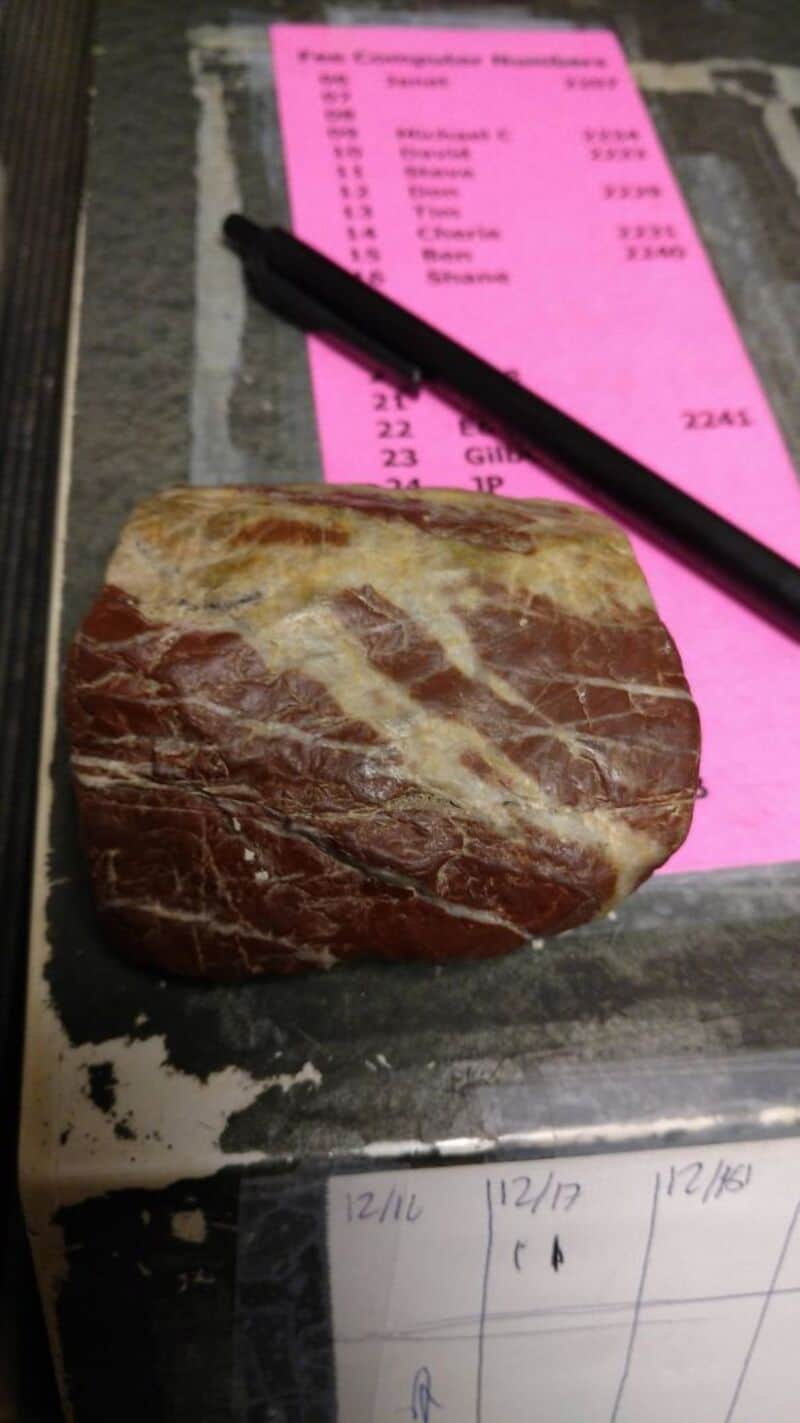 Stone on a counter with a pink receipt and a black pen.