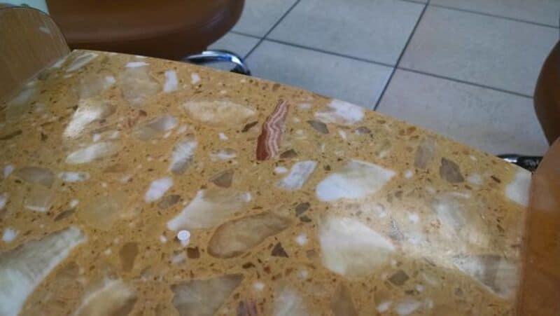 Close-up of a polished marble table surface with beige, white, and brown patterns.