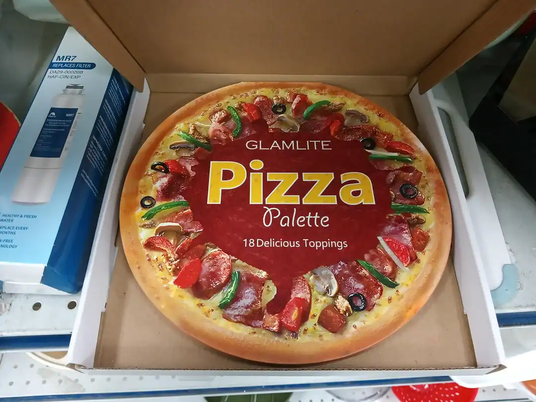 Pizza with vibrant toppings including peppers, olives, and meats in a box.