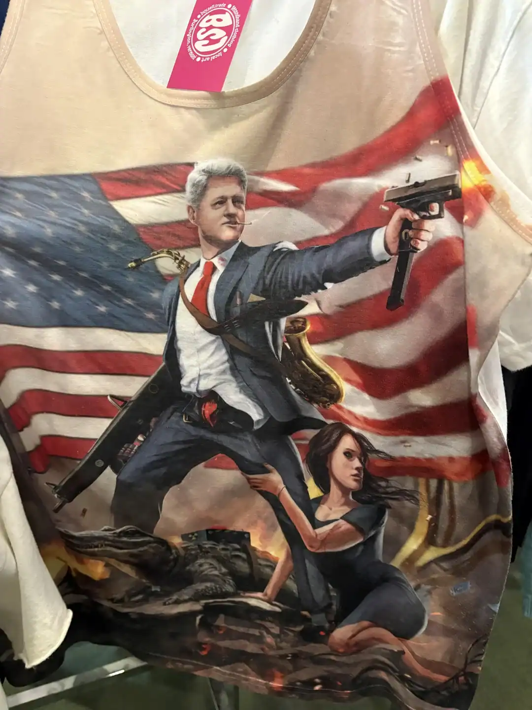 Heroic man holding a gun with woman in front of American flag on T-shirt.