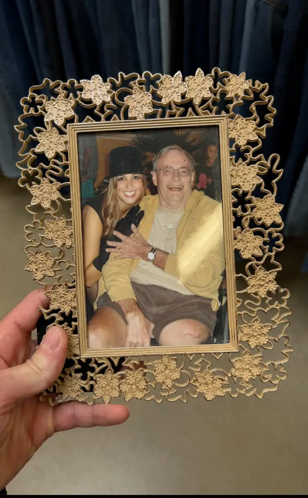 Decorative vintage photo frame with floral patterns holding a picture of a smiling woman and an elde.