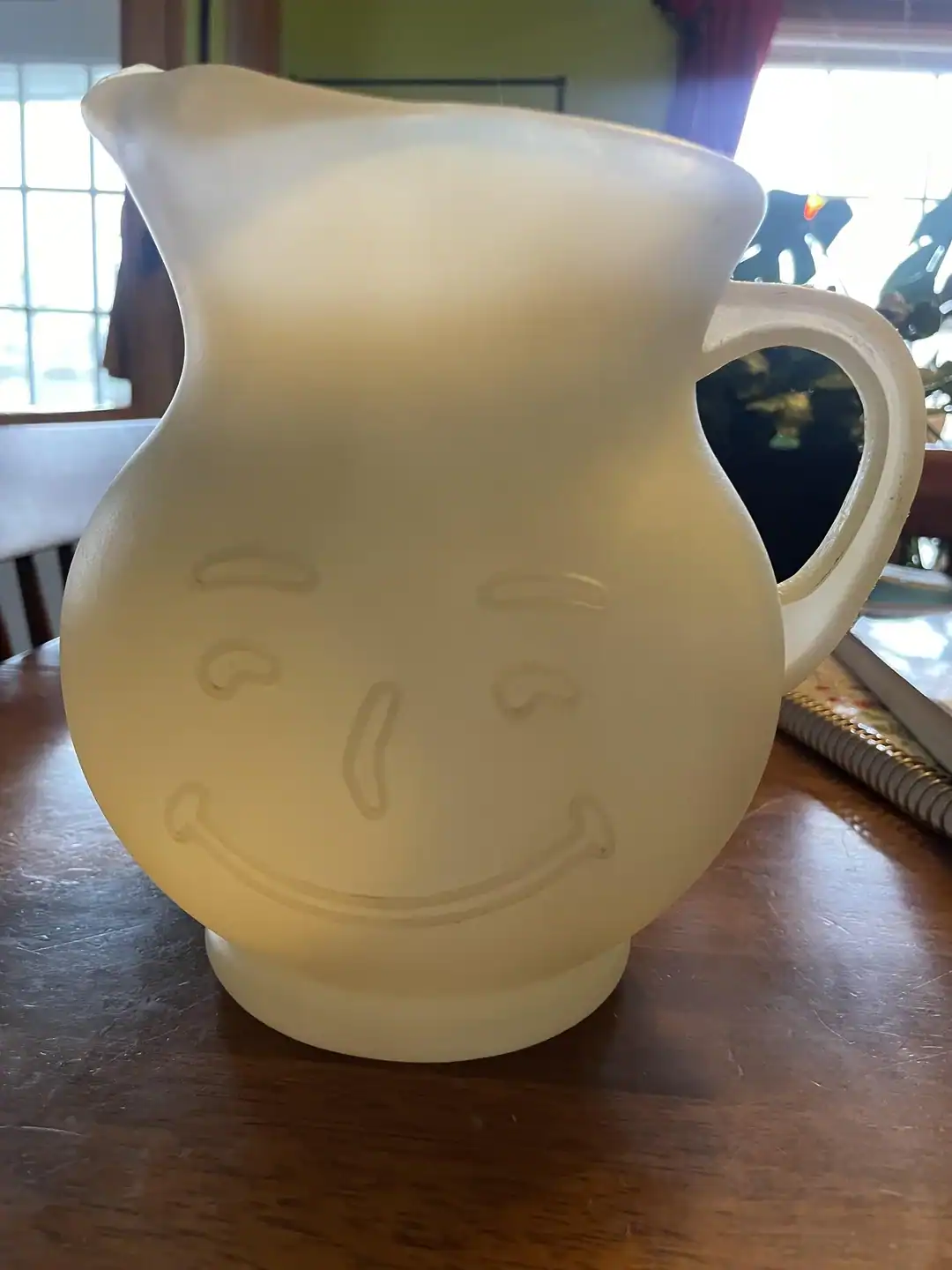 Vintage ceramic pitcher with a smiling face design, perfect for quirky home decor.
