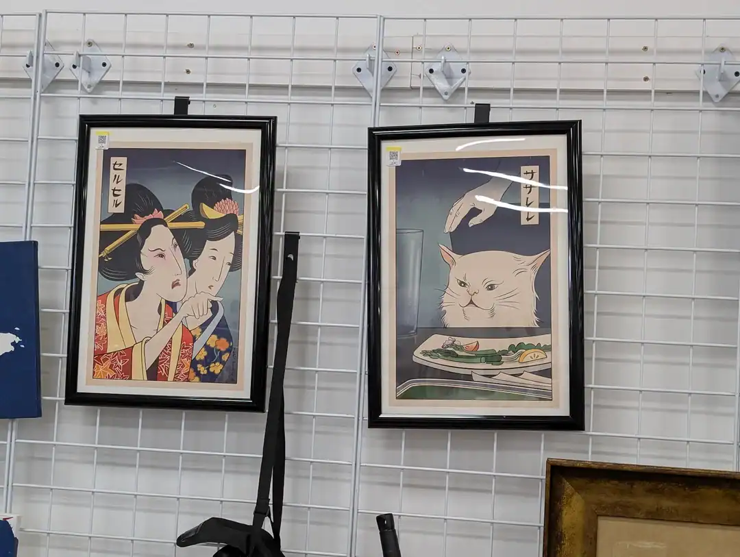 Geisha and cat artwork framed prints on display.