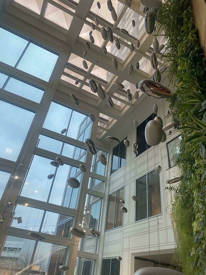 Elegant contemporary interior with artistic metal art installation and abundant natural light.