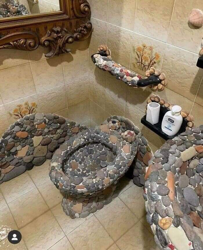 Unique pebble mosaic toilet with stone accents in a bathroom setting.