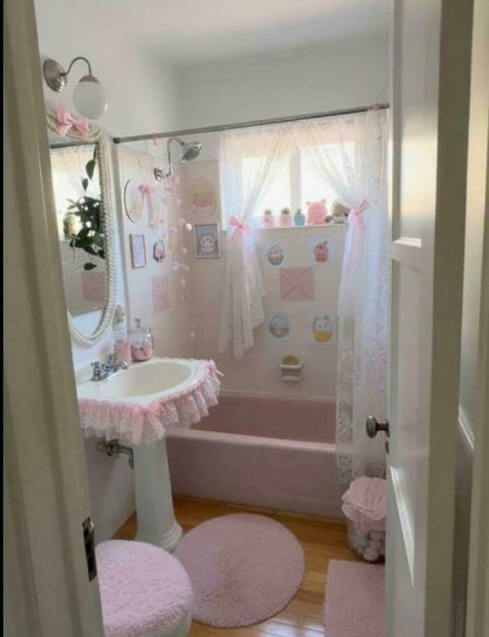 Charming pink-themed bathroom with vintage decor, soft curtains, and plush accessories.