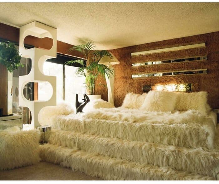 Cozy bedroom with fluffy fur bedding, modern decor, and natural light.