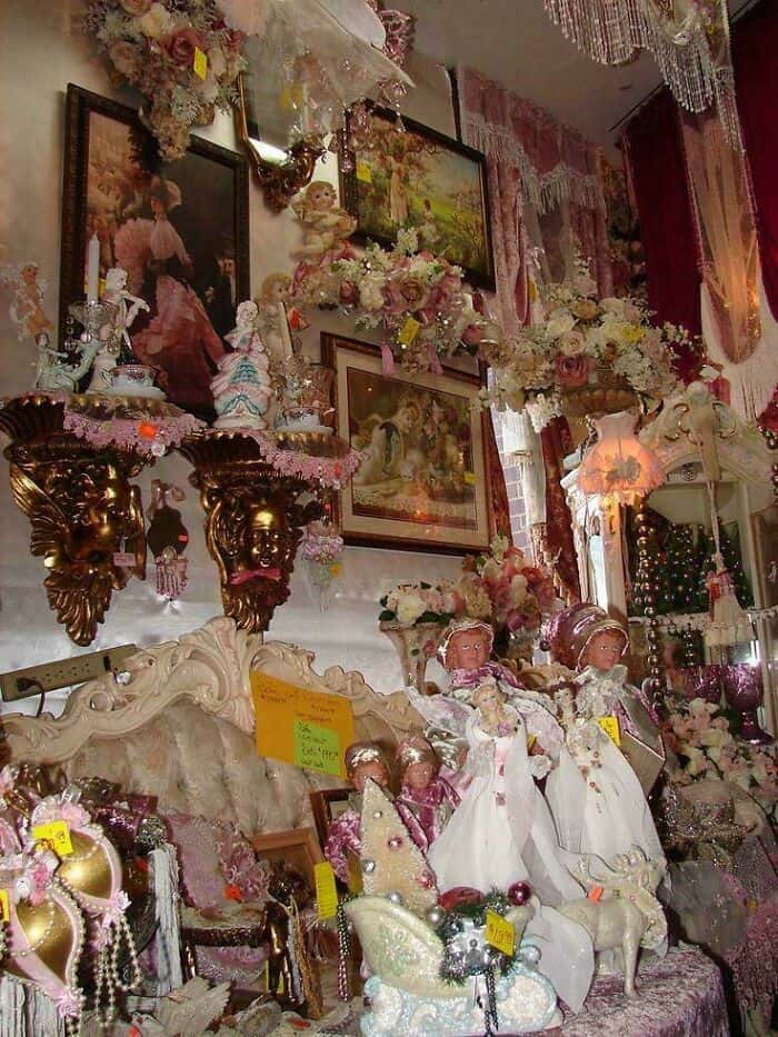 Vintage Victorian doll collection with ornate furniture and floral decorations.